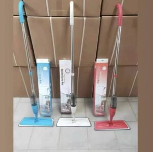 Three floor spray mops in blue, white, and red colors standing next to their original retail boxes on a tiled floor.